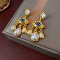 Detail von Vintage Gold-Ohrringen mit bösem Blick und eleganten Perlenquasten-Anhängern - Gold