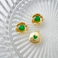Detailed macro of 14k gold plated heart pendants with green zircon in a glass tray - Gold Base-Green Heart Stone