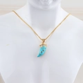 Détail du collier corne dorée avec incrustation turquoise et zircons sur un buste blanc - Petit / Petit Bleu