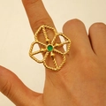 Close-up of gold hollow flower ring with a round green gemstone on woman finger - Emerald Hollow Flower (K-240)