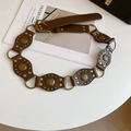 Detail of vintage brown leather waist belt with embossed brass discs and metal studs - Brown