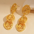Detail view of gold spiral geometric earrings on textured stone, modern artistic design - Triple Layer Spiral Drop Earrings / Gold