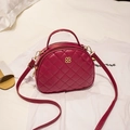 Quilted crossbody handbag in deep burgundy with gold clover ornament and strap - Red