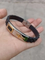 Detailed close-up of a black silicone sports wristband with a golden cross on a steel plate - Steel Shell Gold Cross