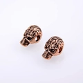 Macro shot of antique red copper skull charm with detailed carving for jewelry DIY - Antique Rose Gold
