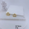 Detail of gold heart earrings with micro-inlaid cubic zirconia on a white stone pedestal - Gold Heart