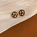 Primer plano de pendientes vintage de esmalte y perlas sobre tela de seda blanca suave - Pendientes de Botón Redondos de Perla Esmalte Negro