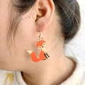Cute asymmetric orange acrylic fox drop earrings worn on ear showing stylish jewelry detail - Smiling Fox / Red