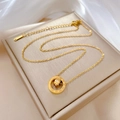 Golden titanium steel necklace with Roman numeral double ring pendant on white silk fabric - Gold