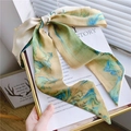 Détail d'un foulard en soie au motif paysage noué en ruban sur une page de livre - Style Paysage 2