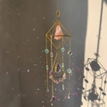 Detalle de atrapasueños de cristal con marco dorado y piedra rosa proyectando arcoíris - 49-51cm / Aleación de Oro + Cuarzo Rosa