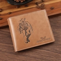 Cartera bifold de cuero marrón con diseño grabado sobre fondo de madera oscura - café