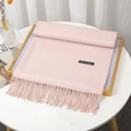Elegant pale pink cashmere-feel scarf with tassels folded on a wooden tray - Sakura Pink