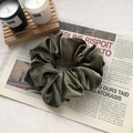 Donkergroene fluwelen haarelastiek met elegante textuur op vintage krant - Donkergroen