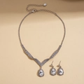 Vista de cerca del collar con colgante de gota plateada y pendientes de cristal - Blanco