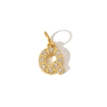 Macro shot of gold-plated letter Q pendant with sparkling zircon inlays on white background - Letter Q Pendant
