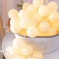Warm white cotton ball string lights displayed in a rustic white metal garden bucket - Pure White