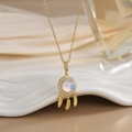 Golden dreamcatcher necklace with moonstone and feathers on white textured pedestal - Gold Moonstone Dreamcatcher