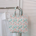 Detailed close-up of floral quilted tote bag with pink rose pattern and logo tag - Green Leaf Red Rose