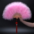 Detailed view of pink feather folding fan with hollow star moon pattern and red tassel - Pink