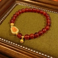 Dettaglio del bracciale di perle di diaspro granato con ciondolo a zucca dorata - Stile Zucca Granato Arancione