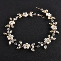 Detailed view of bridal headpiece featuring gold wire, white pearls, and crystals - Gold