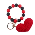 Nahaufnahme von rotem Strickherz-Anhänger und Perlenarmband mit goldenem Schlüsselanhänger - Rot