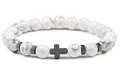 Macro shot of white marble beads and a black metal cross charm on an elastic bracelet - White Howlite
