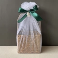 Detail of woven seagrass basket with star tulle wrap and green satin ribbon bow - Dark Green Full Wrap Star Moon Mesh