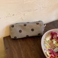 Detail view of a grey corduroy cosmetic bag with brown polka dots on a wooden table - S / Grey Polka Dot