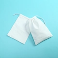 Two white cotton drawstring pouches for jewelry storage on a light blue background - 7*9cm / White Cotton White String