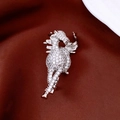 Dettaglio macro di una spilla a forma di cavallo placcata oro con zirconi su seta - Argento