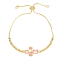 Dettaglio di un bracciale regolabile in oro con ciondolo a croce in pietra rosa e perle - Rosa