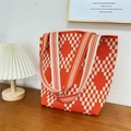 Detail of knitted tote bag with orange and white checkerboard pattern on a wooden table - 14 Small Diamond Orange