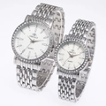 Close-up of silver steel couple watches with rhinestone bezel and white quartz dial - Men's Silver Case White Dial