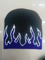 Detail der Strickmütze mit lila-weißem Flammenmuster auf schwarzem Untergrund - M / Lila