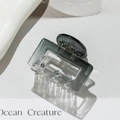 Close-up of a translucent grey square hair claw clip with Ocean Creature text - Square Black