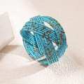 Detailed close-up of bohemian multi-layer blue and gold beaded wide cuff bracelet - Blue