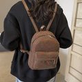 Detail of brown corduroy backpack featuring strawberry embroidery and adjustable straps - Brown