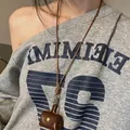 Détail d'un collier pendentif chat en cuir marron avec un bouton en métal doré - 16# Collier-Marron