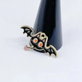 Detailed view of a bat-shaped black and gold metal ring holder with enamel accents - Bat