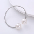 Macro shot of silver-tone wire-wrapped bangle with two large round white pearls - Pearl Style