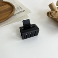 Detail shot of a black matte square hair claw clip on a wooden display tray - 12# 18088 Black Cube