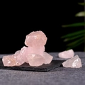 Bulk unpolished raw pink crystal quartz stones displayed on a black stone plate - Pink Crystal Stone (150g)