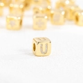 Macro shot of a 18k gold plated cube pendant featuring a sparkling zircon letter U - U (Single Pendant)