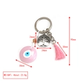 Detail view of pink evil eye keychain with tree of life charm and silk tassel pendant - Pink Disc Tree of Life Tassel