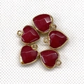 Detailed view of red heart-shaped gemstone pendants with golden metal frames and hoops - 15x18mm / Red Stone