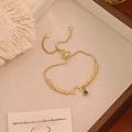 Detail of adjustable gold beaded bracelet with moon charm and blue evil eye pendant - Moon Style (C)