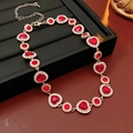Detalle macro de collar vintage de corazón dorado con gemas rojas y acentos de diamantes - Collar Corazón con Diamantes de Imitación - Dorado - Rojo