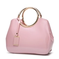 Elegant pink patent leather handbag for women featuring circular gold metal handles - Pink